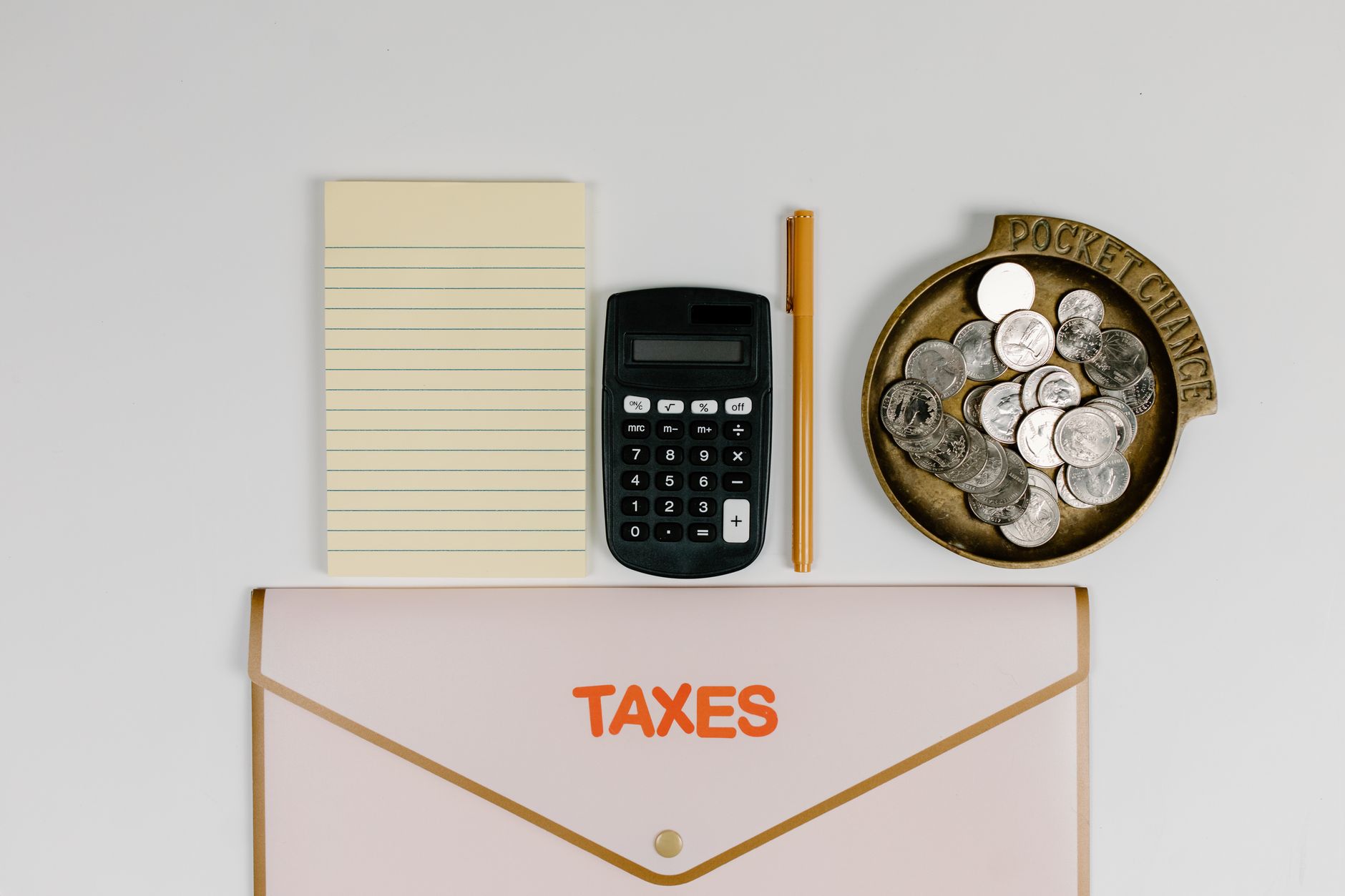 Calculatrice, pièces de monnaie et documents fiscaux pour le calcul d'un amortissement professionnel
