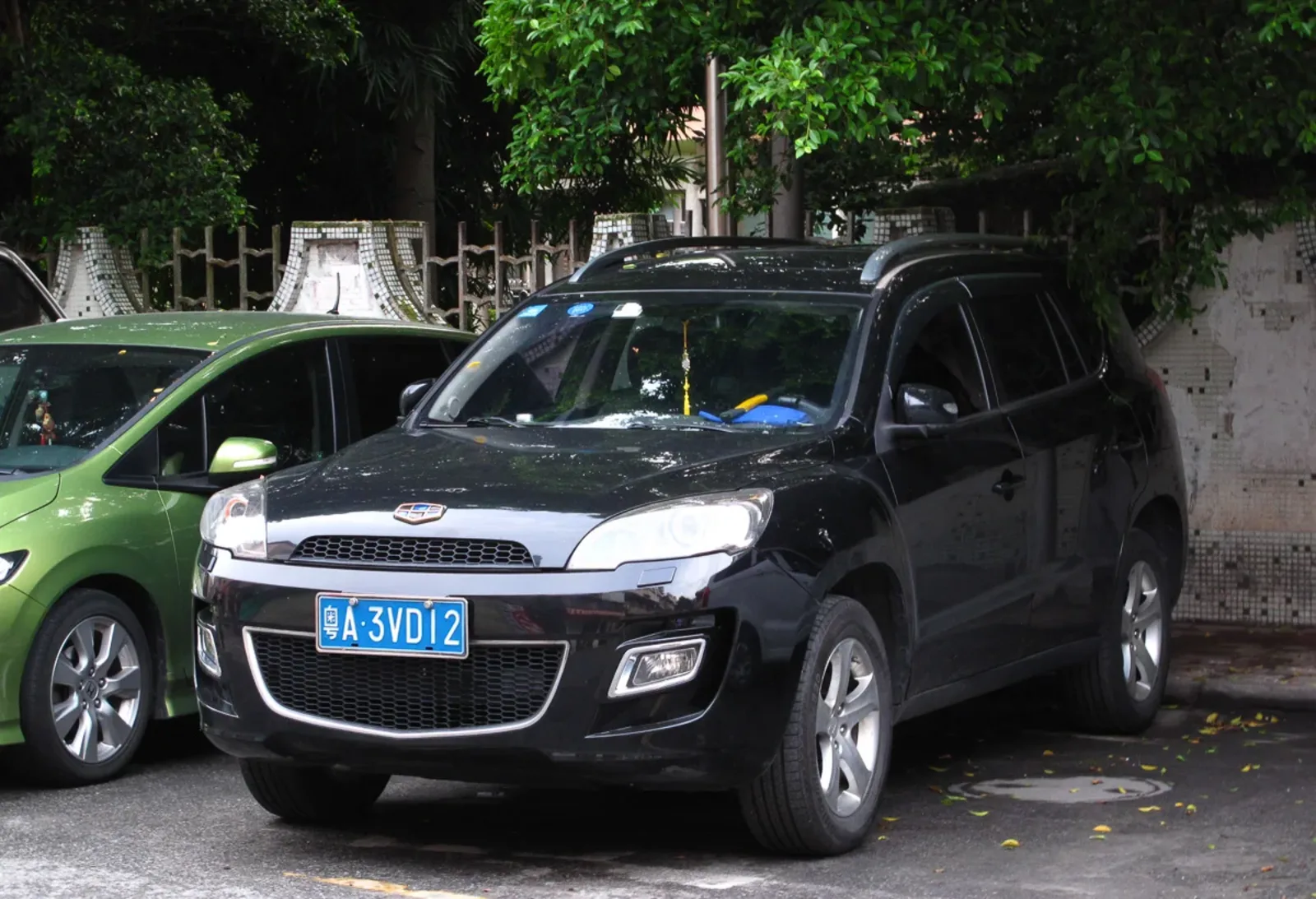 SUV Geely gris de trois quarts avant, garé en extérieur